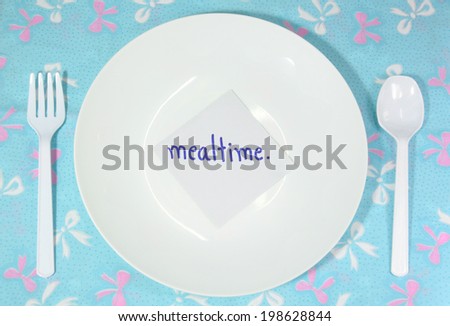 white empty plastic plate and cutlery with mealtime card (remind for mealtime)