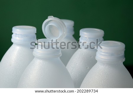 rows of white plastic bottles isolated on green background
