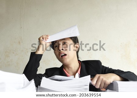 businesswoman serious with pile of paper