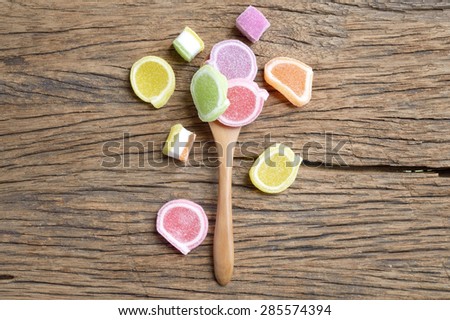 jelly candy dessert in wooden spoon on wood background