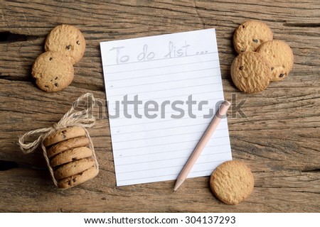 write to do list on wooden table with chocolate chip cookie