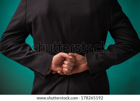 Man in suit holding his hands on his back