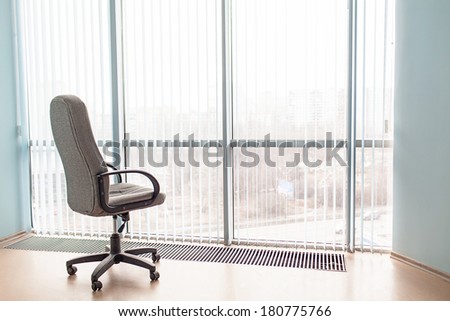 Office armchair in a light room and a landscape in a window