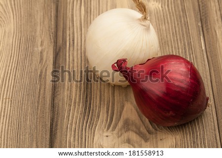 Fresh raw red and white onions on a wooden table with copy space. Close-up studio photography.