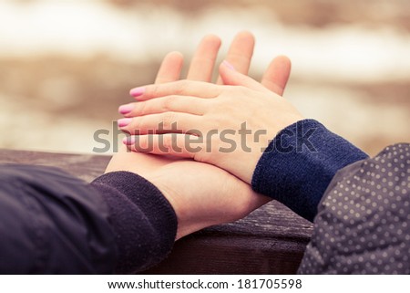 Concept shot of friendship and love of man and woman: two hands over nature park