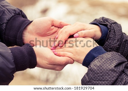 Concept shot of friendship and love of man and woman: two hands over nature park