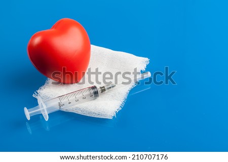 red heart with syringe on the blue background