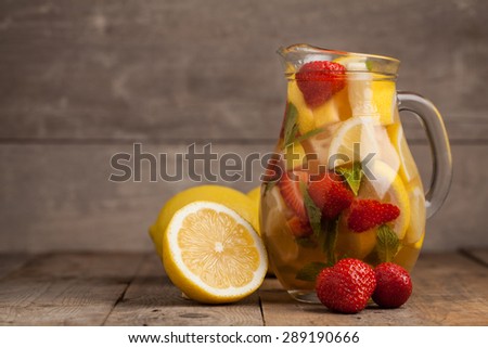 Strawberry lemonade with lemon on wooden table. Selective focus.