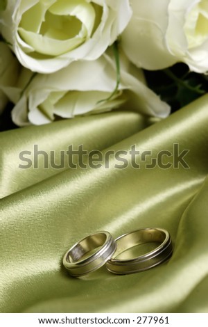 pair of wedding bands on green satin