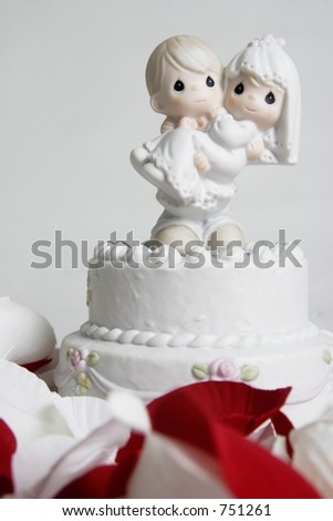 Cute ornament of groom carrying bride on top of wedding cake