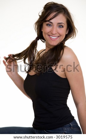 Portrait of an attractive happy brunette in pigtails in casual attire smiling sitting on white background