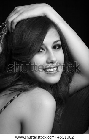 Close up of beautiful brunette woman with hand on head on black
