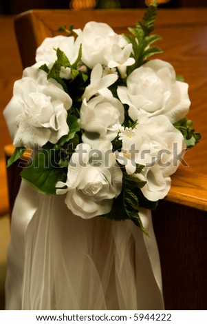 stock photo Flower arrangement in a church on side of pew