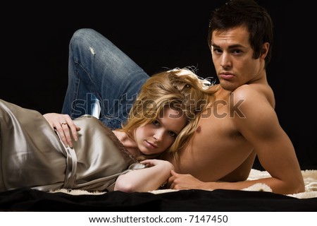 Attractive young blond woman laying on the bare chest of attractive young brunette man