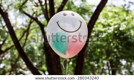 transparent  balloon with smile face on green bokeh background