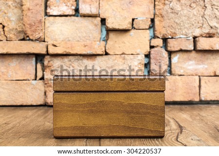 blank wooden box with stone wall  backgroubd