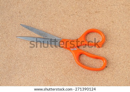 Yellow scissors isolated on a wood background