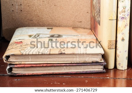 old photo album over rustic wooden background in vintage color
