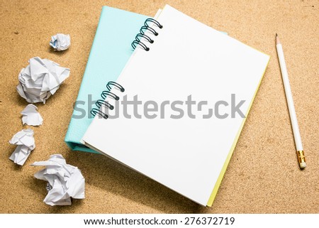 Notebook papers, pencil and crumpled paper ball   on wooden background