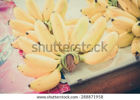 Yellow and green bananas are arranged in a pile in a grocery store - Vintage filter, Shallow DOF