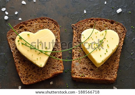 Two slices of bread with a heart shaped pieces of butter