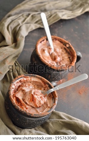 Two cups of chocolate mousse on a dark table