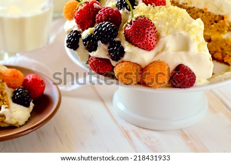 Old fashioned home baked cake with light cream decorated with freshly picked berries. Close up
