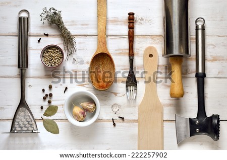 Kitchen utensils on a light rustic wooden background