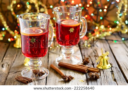 Traditional Christmas punch with spices such as cinnamon and star anise in a glass cups decorated with golden stars Traditional Christmas punch with spices such as cinnamon and star anise in a glass cups decorated with golden stars