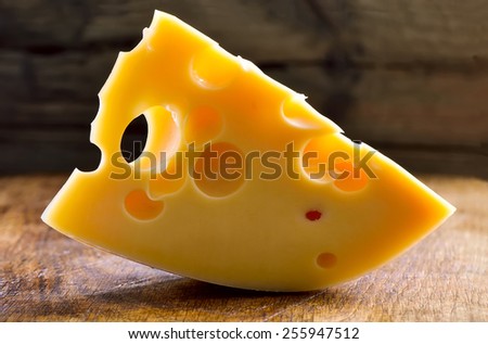 Block of cheese on a wooden background