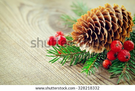 Christmas vintage background, pine cone and winter berries in a bunch of coniferous branches, stylized photo