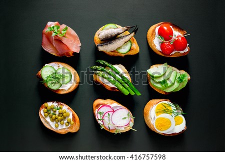 Sandwiches on a dark background, or assorted canapes, top view