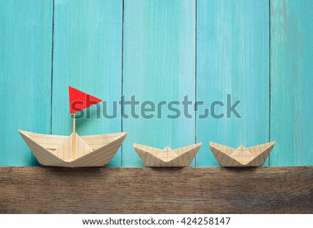 Origami paper boats on a wooden background, summer traveling concept