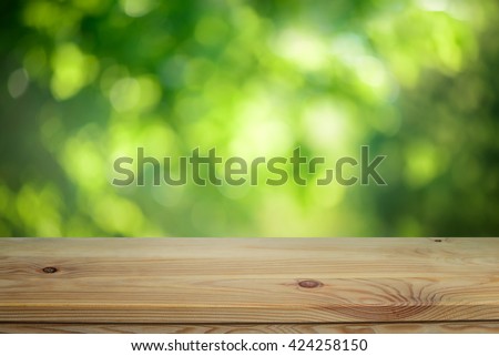 Plain wooden table surface on a blurred outdoor background