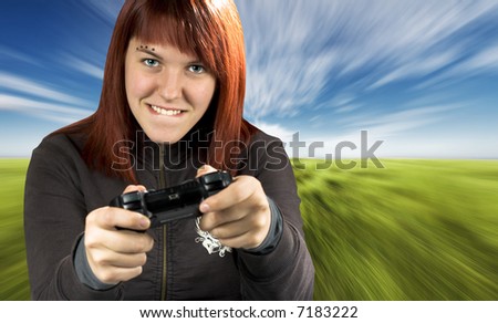 Redhead girl joyfully playing video games console. Background is conceptualized to be used for a driving game (motion blur). Shot in studio, processed in PS with a composite background.