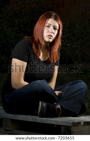 Girl siting on wood, flash lighting, redhead. Lit with two off-camera flashes.