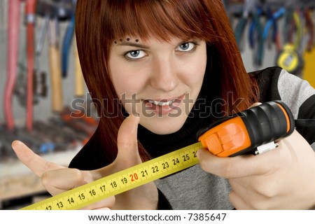 Beautiful seductive redhead girl gesturing a 20 centimeter length on a measuring tool. Studio shot.
