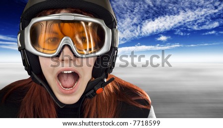 Cute girl with red hair wearing a ski helmet and orange goggles acting surprised and yelling. Feeling cold. Studio shot.