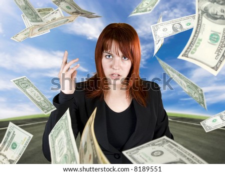 Angry and pretty redhead girl throwing Dollar banknote money towards the camera.