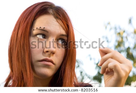 stock photo Portrait of a cute redhead looking at one hair with eyes 