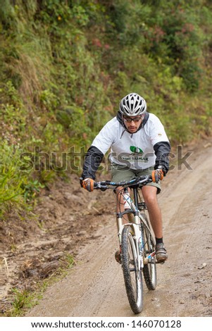 ZAMORA REGION, ECUADOR-JULY  13 2013:Rider Fernando Ortega Aguirre  in the rain and mud in the Andes Mountains on July 13, 2013. Governments in Ecuador are actively promoting fitness activities.