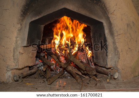 Traditional wood fired oven in the Andes region of Ecuador with flames and sticks