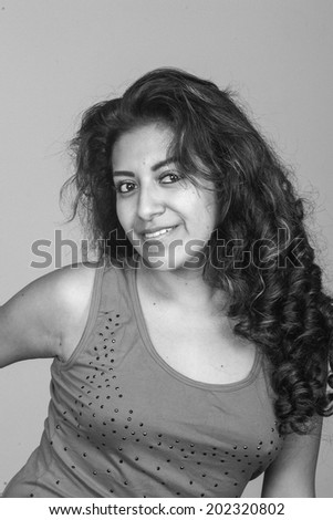young attractive Ecuadorian lady in studio,jeans, black and white, eyes to camera smile