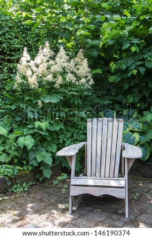 Lazy armchair in front of an aruncus  the garden