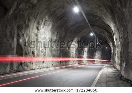 Long time exposure of car driving through natural-rocks-tunnel