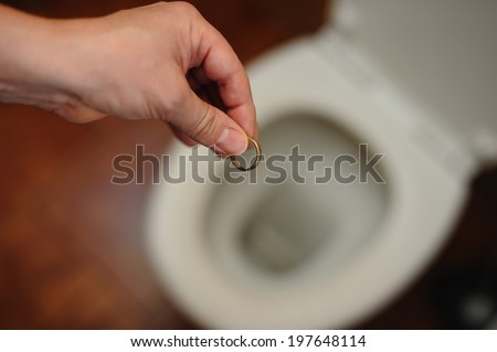 hand that throws a wedding ring in the toilet bowl