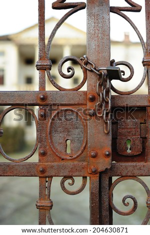 old and rusty gate with chain and padlock