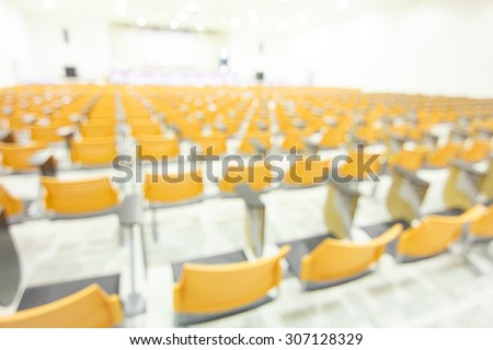blurred image of many row of chairs set for conference, dinner or meeting event with large hall ,no people.