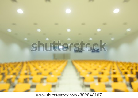 blurred image of many row of chairs set for conference, dinner or meeting event with large hall ,no people.