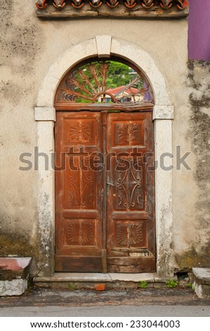 old ruined building facade and wooden door. a stylized picture under oil painting